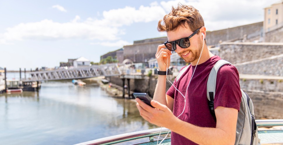 Man with headphones in listening to Plymouth Trails app 